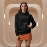 Woman wearing an augmented reality black hoodie with text design in a beige architectural setting