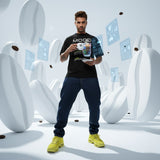 Man holding an espresso in a futuristic setting, wearing a black t-shirt with QR code for AR video activation.