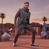 Man in a stylish outfit, featuring a vintage black hoodie with QR code for AR video activation, standing in a desert setting with palm trees and modern architecture.