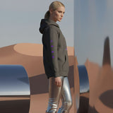 Female model wearing a vintage black hoodie with purple accents and QR code for AR video activation, in a desert-like setting